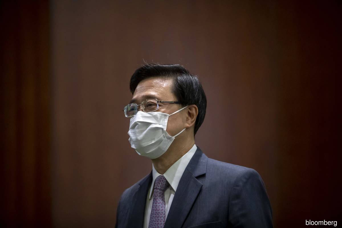 Hong Kong Chief Executive John Lee's nearly three-hour speech didn’t address pandemic curbs until its final moments, and even then offered no specifics of how the city would emerge from restrictions that still subject arrivals to days of PCR tests, outdoor mask mandates, and an initial ban on visiting bars and restaurants.